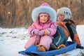 Children sits on plastic sled Royalty Free Stock Photo