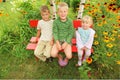 Children sitting on bench in garden