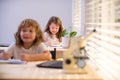 Children sitting at desk in school classroom and writing test. Schoolkids writing in notebook during lesson in class. Royalty Free Stock Photo