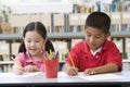 Children sitting at desk and writing in classroom Royalty Free Stock Photo