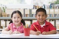 Children sitting at desk and writing in classroom Royalty Free Stock Photo