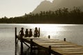 Children Sitting On Edge Of Jetty At Sunset Royalty Free Stock Photo