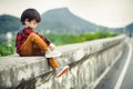 Children sitting on the gound and mountain is back. Royalty Free Stock Photo