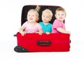 Children sitting inside red suitcase