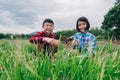 Children sitting in organic vegetables garden on sunny and sky background in rural or countryside Royalty Free Stock Photo