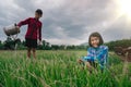 Children sitting in organic vegetables garden on sunny and sky background in rural or countryside Royalty Free Stock Photo