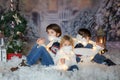 Children, sitting in the snow, wrapped in toilet paper and christmas light strings