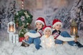 Children, sitting in the snow, wrapped in toilet paper and christmas light strings Royalty Free Stock Photo