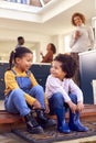 Children Sitting On Step At Home Putting On Boots Before Going On Family Walk With Grandparents Royalty Free Stock Photo