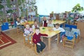 Children sitting at the tables in kindergarten. Happy kids. Baby smiling