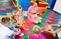 Children sitting with teacher and listening to music in class Royalty Free Stock Photo