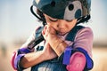 Children, skater and plaster with an injured girl looking at her sore arm while skating outdoor in a helmet and pads