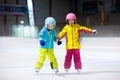 Children skating on indoor ice rink. Kids and family healthy winter sport. Boy and girl with ice skates. Active after school
