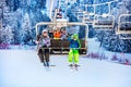 Children on ski lift wave hands over snow forest Royalty Free Stock Photo