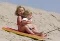 Children sledding down sand dune