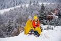 Children sledding, riding a sledge. Children son and daughter play in snow in winter. Outdoor kids fun for Christmas Royalty Free Stock Photo