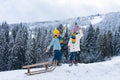 Children sledding, riding a sledge. Children son and daughter play in snow in winter. Outdoor kids fun for Christmas Royalty Free Stock Photo