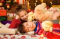 Children sleeping in new year or christmas decoration. Teenage boy and girl. Holiday lights, gifts and christmas tree decorated
