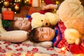 Children sleeping in new year or christmas decoration. Teenage boy and girl. Holiday lights, gifts and christmas tree decorated Royalty Free Stock Photo