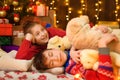 Children sleeping in new year or christmas decoration. Teenage boy and girl. Holiday lights, gifts and christmas tree decorated Royalty Free Stock Photo