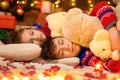 Children sleeping in new year or christmas decoration. Teenage boy and girl. Holiday lights, gifts and christmas tree decorated Royalty Free Stock Photo