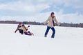 Children sleigh riding - their mother helping Royalty Free Stock Photo