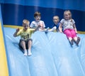 Children slide down inflatable slides at an amusement park