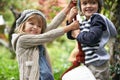Children, smile and swing in a backyard in winter together with sibling and fun in garden. Youth, nature and excited on Royalty Free Stock Photo