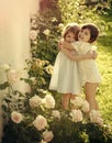 Children smiling at blossoming rose flowers