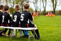 Children Soccer Team on a Bench. Young Football Team Players. Young Boys in Black Shirts as a Substitute Soccer Players Royalty Free Stock Photo