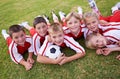 Children, soccer team and portrait with ball, boys and girls on field, happy and united. Energy, sports and friendship Royalty Free Stock Photo