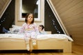 Children in soft warm pajamas playing at wooden cabin home. Concept of childhood, leisure activity, happiness. Brother and sister