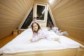 Children in soft warm pajamas playing at wooden cabin home. Concept of childhood, leisure activity, happiness. Brother and sisters Royalty Free Stock Photo