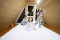 Children in soft warm pajamas playing at wooden cabin home. Concept of childhood, leisure activity, happiness. Brother and sisters Royalty Free Stock Photo