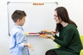 Children speech therapy concept. Preschooler at speech therapy doing breathing exercises with a female speech therapist.