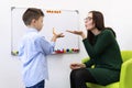 Children speech therapy concept. Preschooler at speech therapy doing breathing exercises with a female speech therapist.