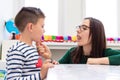 Children speech therapy concept. Preschooler practicing correct pronunciation with a female speech therapist. Royalty Free Stock Photo