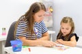 Children speech therapy concept. Preschooler practicing correct pronunciation with a female speech therapist. Royalty Free Stock Photo