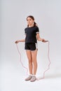 Children and sport. Full-length shot of a cute teenage girl skipping with a jump rope isolated over grey background in Royalty Free Stock Photo