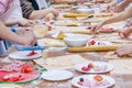 Children& x27;s hands are cutting food for making their first pizza on wooden table. Cooking master class