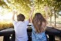 Children Standing Up In Back Of Open Top Car On Road Trip Royalty Free Stock Photo