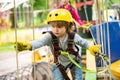 Children summer activities. High ropes walk. Every childhood matters. Happy little boy calling while climbing high tree Royalty Free Stock Photo
