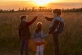 Children at sunset in the field show a heart from their fingers. Walk in the fresh air. Silhouette of three children. Beautiful Royalty Free Stock Photo