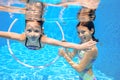 Children swim in pool underwater, happy active girls have fun under water