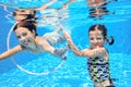 Children swim in pool underwater, happy active girls have fun under water, kids sport Royalty Free Stock Photo