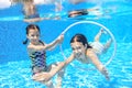 Children swim in pool underwater, happy active girls have fun under water