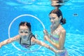 Children swim in pool underwater, happy active girls have fun under water