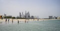 Children swim in the sea on a sandy beach Sufouh against the backdrop of skyscrapers in Dubai, UAE. Clear Sunny day 16