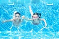 Children swim in swimming pool underwater, happy active girls have fun under water, kids fitness and sport Royalty Free Stock Photo