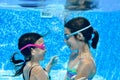 Children swim in swimming pool underwater, happy active girls have fun under water, kids fitness and sport Royalty Free Stock Photo